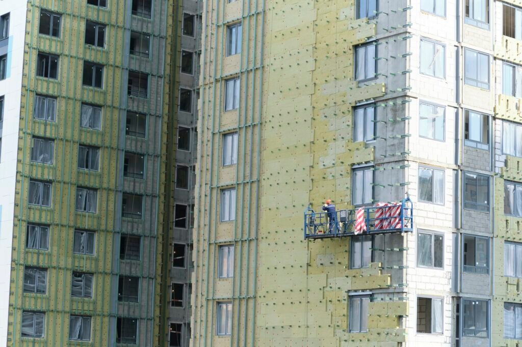 workers are insulating the wall of a building. Construction site.