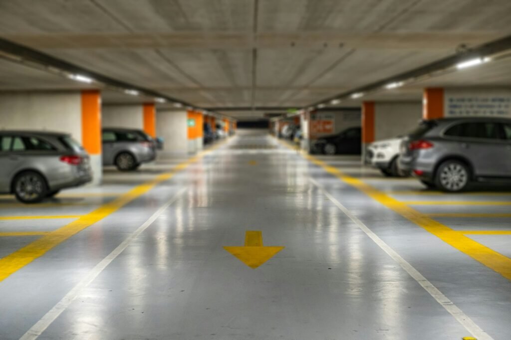 Yellow markings with blurred modern cars parked inside closed underground parking lot.