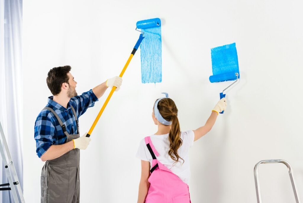 boyfriend and girlfriend painting wall with blue paint