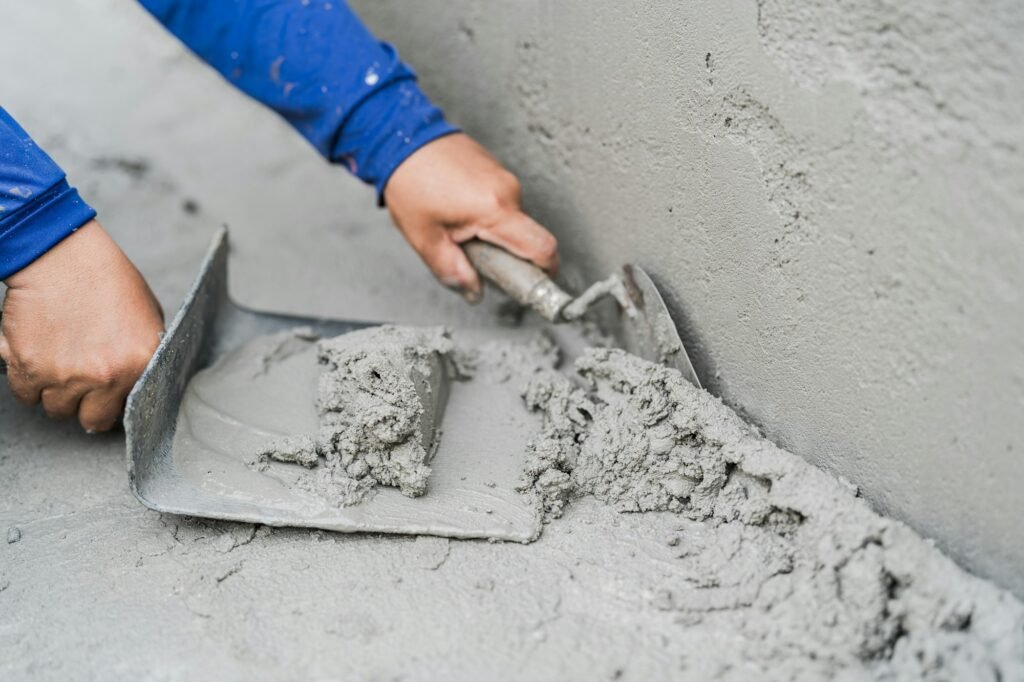 Hand worker plaster cement concrete with trowel tool well space for text