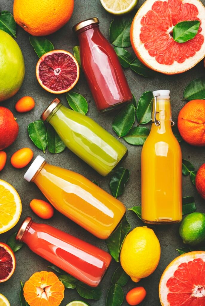 Summer fruit drinks. Citrus juices and smoothies in bottles, food background, top view