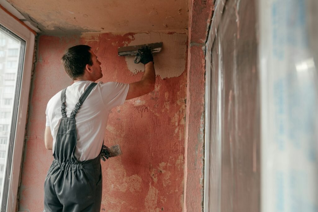 Worker applying putty mortar on the balcony wall