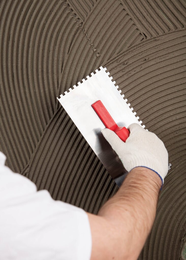 the worker applies tile adhesive for a tile on a wall