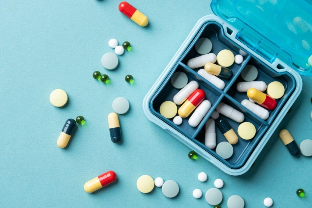 composition with pill box and pills on color background